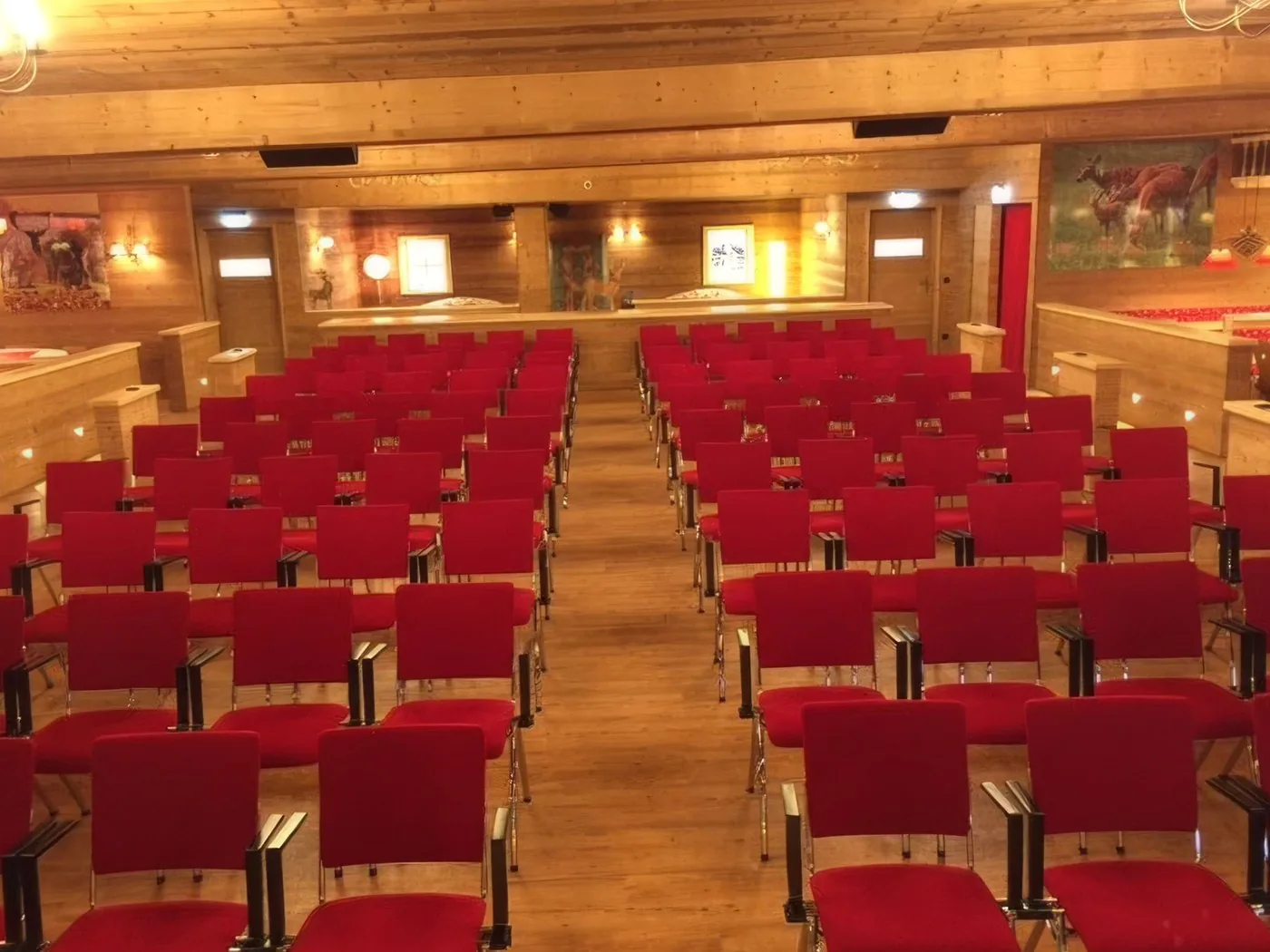 Theaterbestuhlung mit roten Stühlen vor der Bühne der Hirschalm
