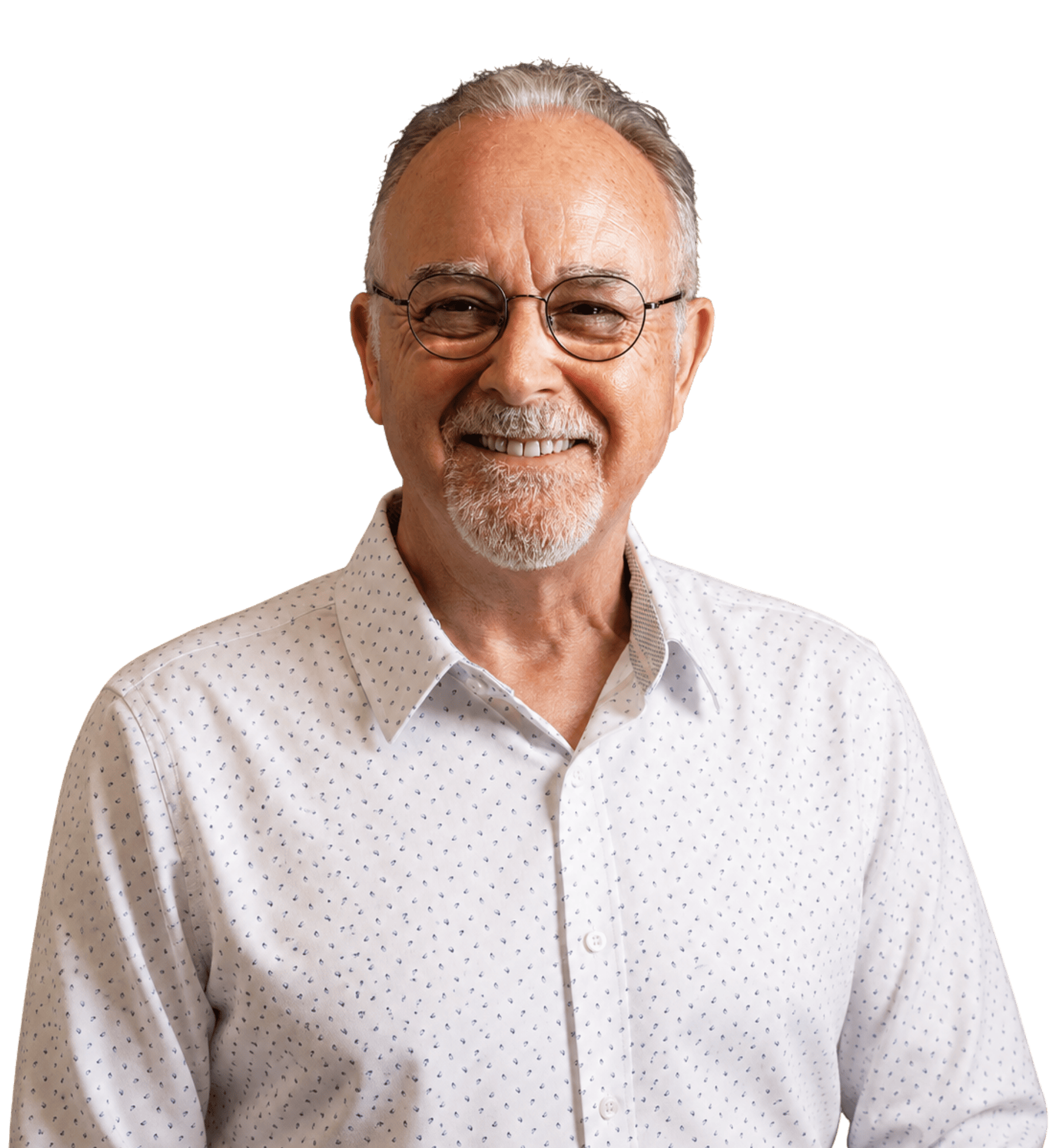Smiling older man with gray beard and glasses wearing white polka dot shirt