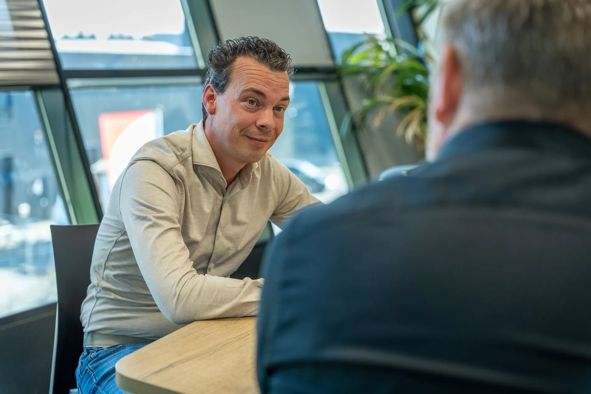 Arbeidsmakelaar in gesprek met kandidaat Arbeidsmakelaar in gesprek met een kandidaat aan tafel op kantoor