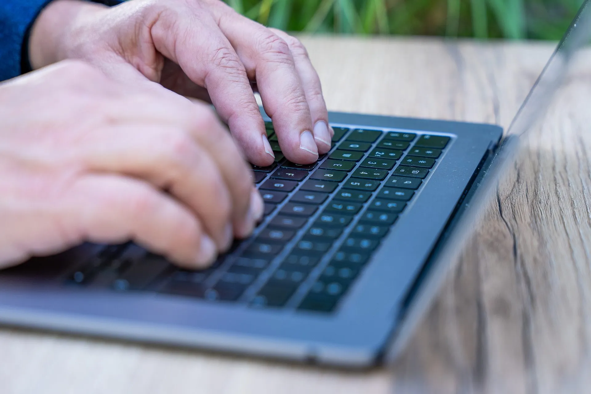 Minder papierwerk, meer recruiten Close-up van handen die typen op een laptop op een houten tafel