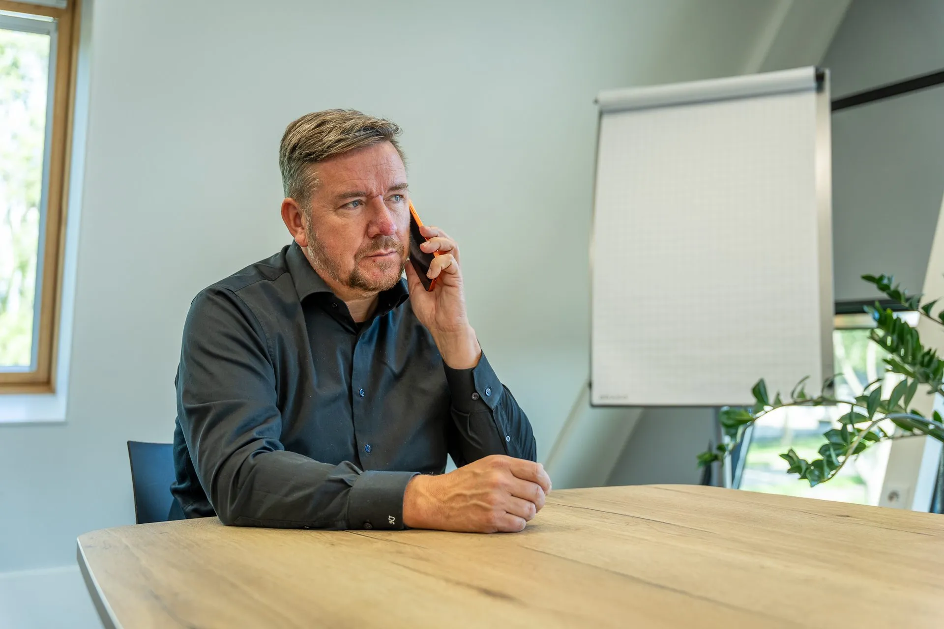 Arbeidsmakelaar belt met een klant Arbeidsmakelaar belt met een klant aan de vergadertafel op kantoor