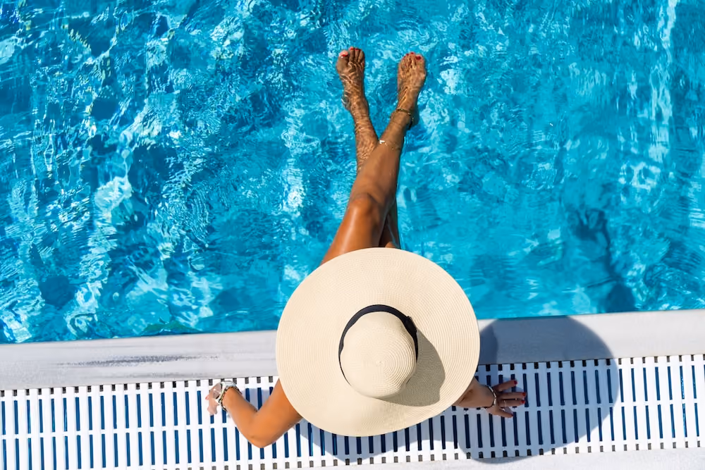 Aerial view of woman sitting on edge of pool