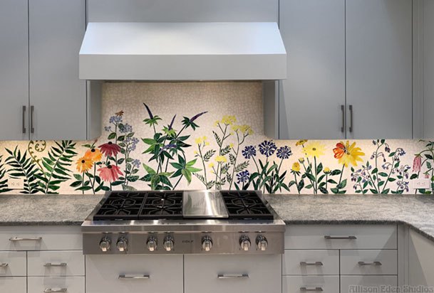 Modern kitchen with botanical flower patterned backsplash and stainless steel range hood.