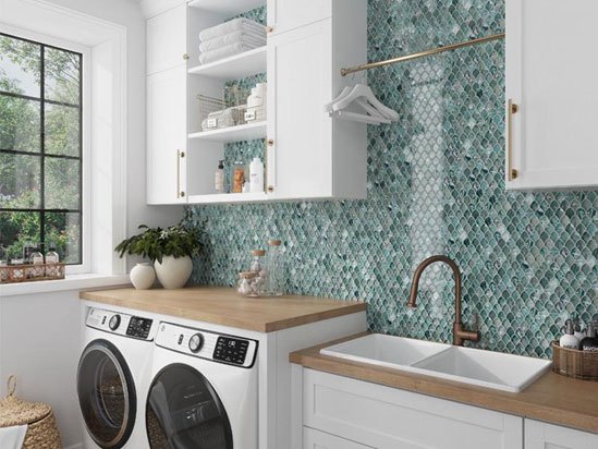Modern laundry room with white cabinetry, green tile backsplash, and washer-dryer combo
