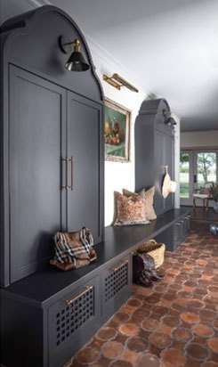 Dark blue entryway with arched cabinetry, hanging bell light, and brick flooring.