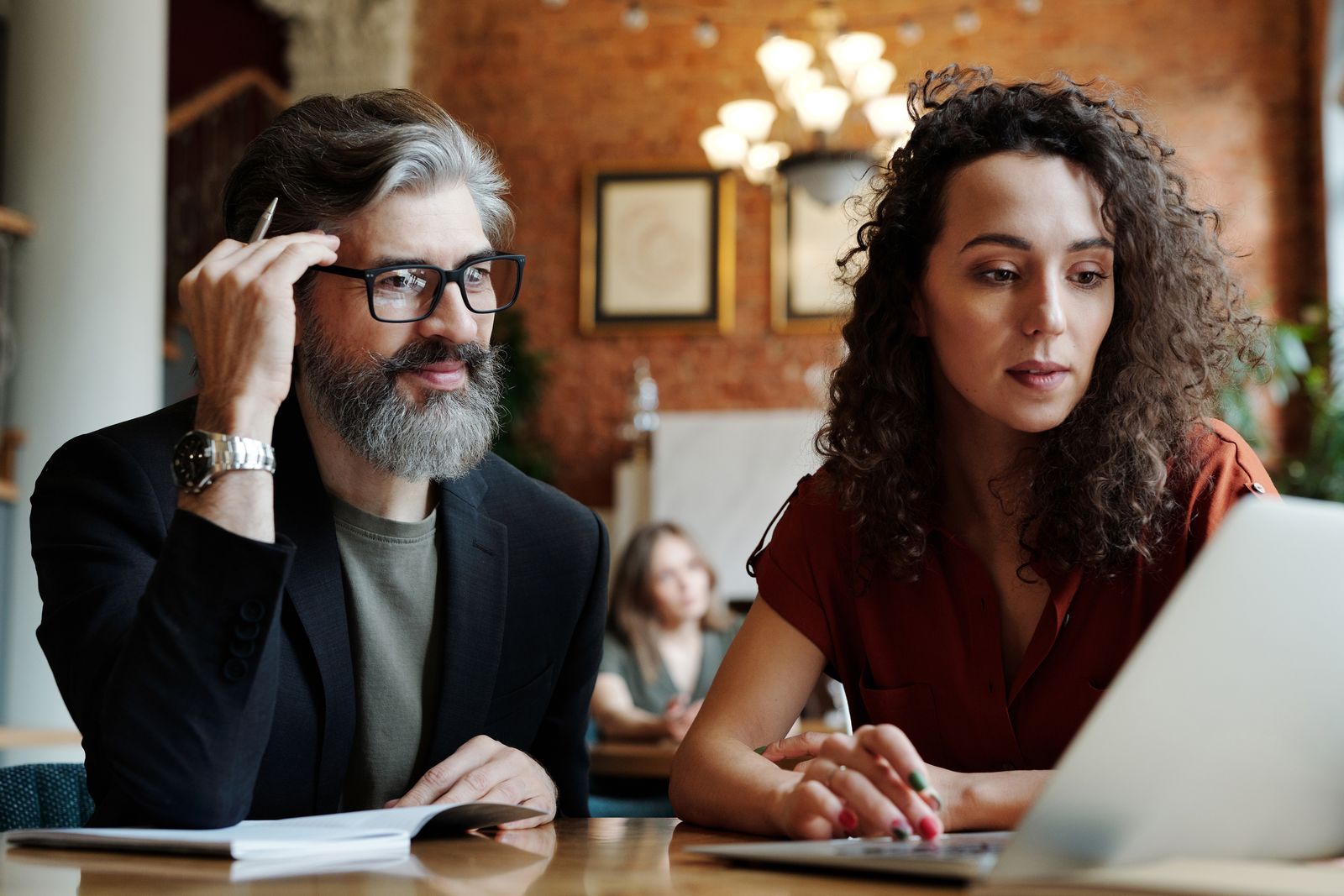 Professionals reviewing a business project with a laptop and documents.