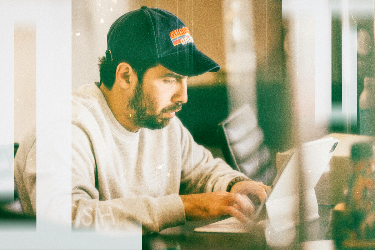 Person focused on a tablet at a desk.