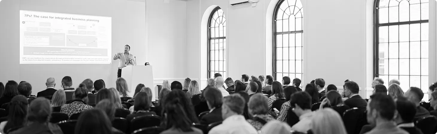 Chris Woodward presenting integrated business planning to a full conference room