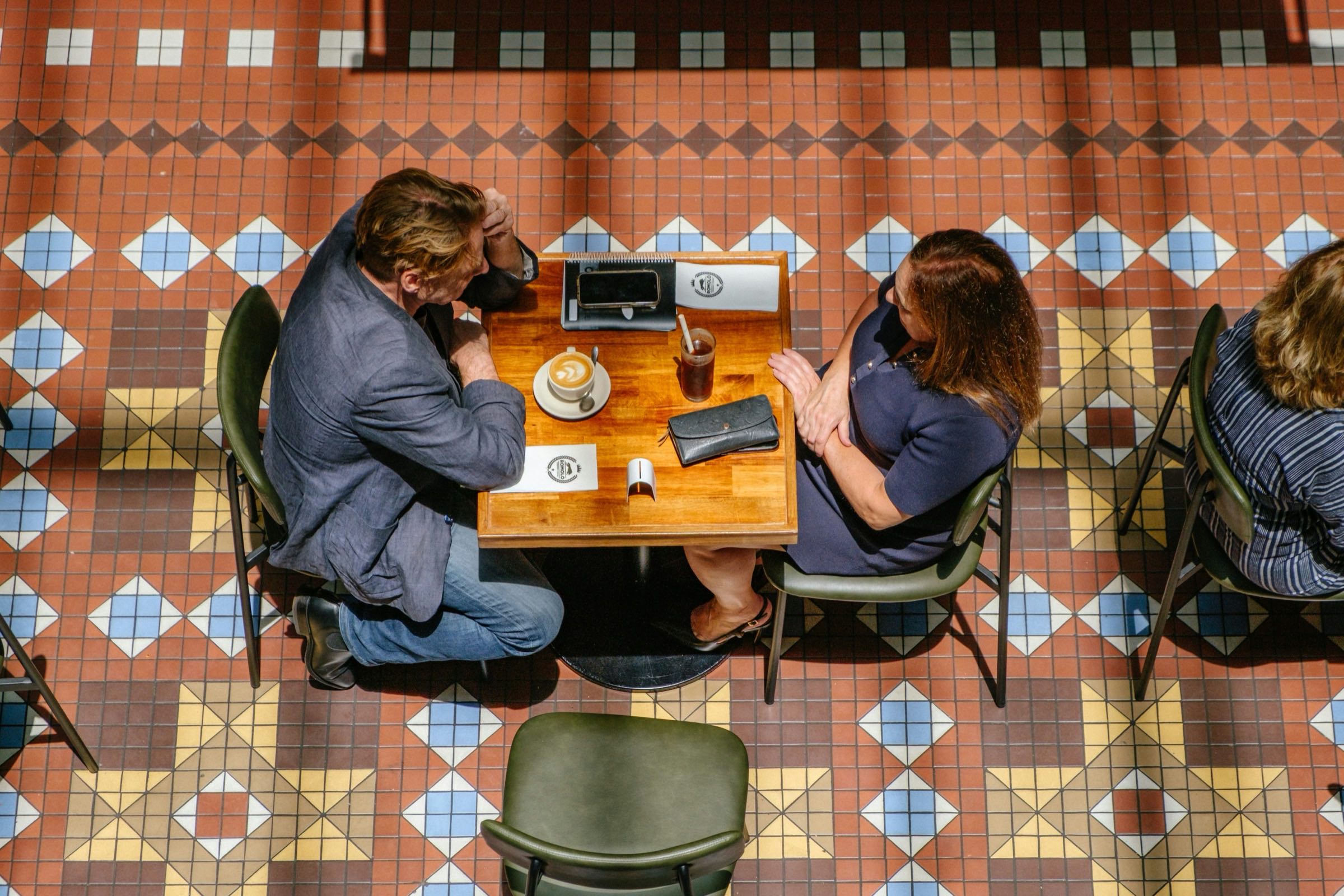 Two people talking across a cafe table, seen from above