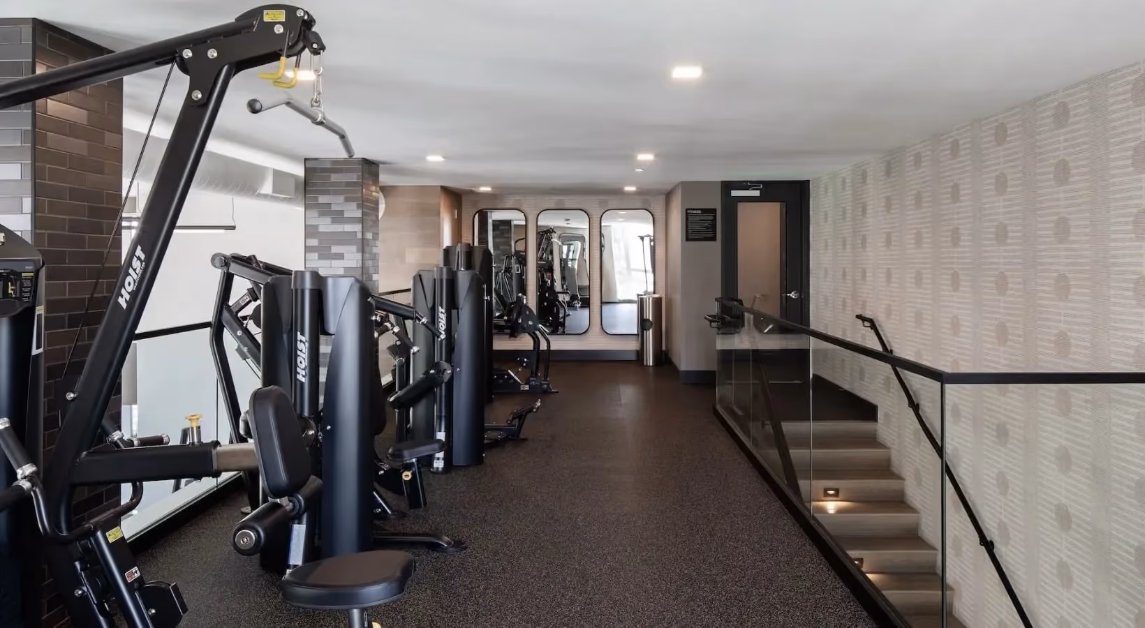 Fitness center with free weights, weight bench, and stairs to second level
