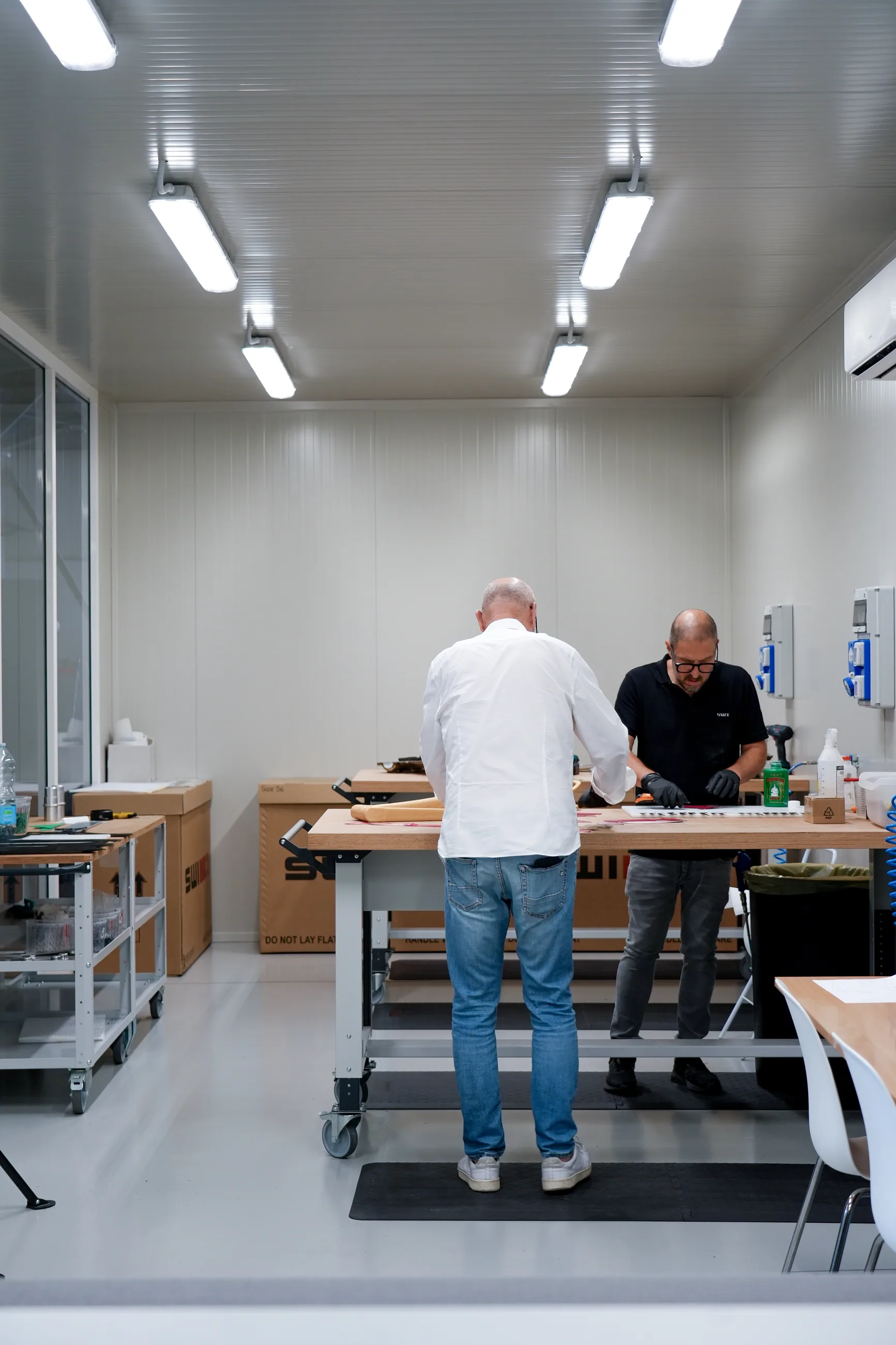 Two SWI craftsmen laying up carbon in the workshop