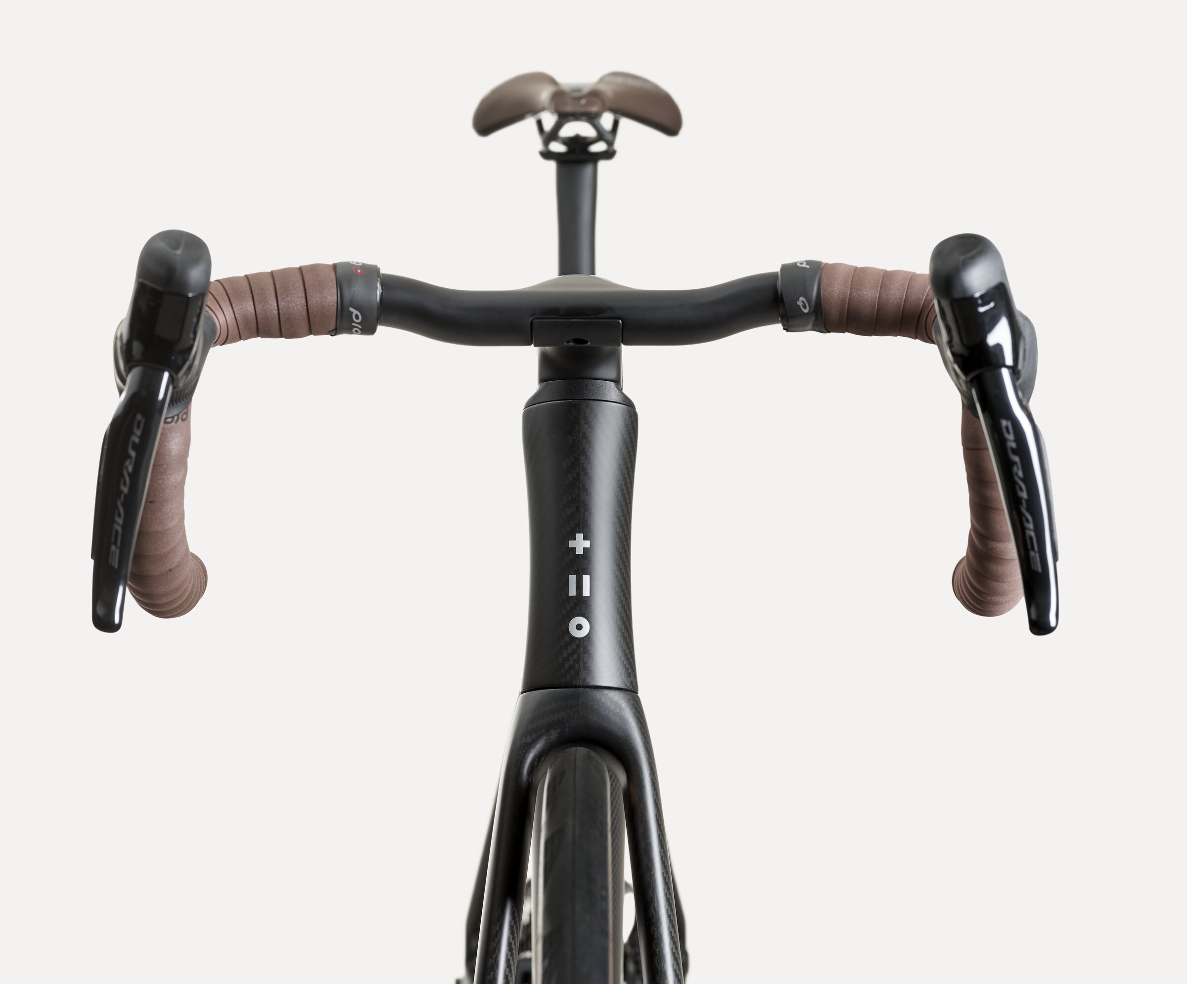 The SWI integrated carbon cockpit fitted to a matt Aequus, seen from the front with the SWI mark on the head tube