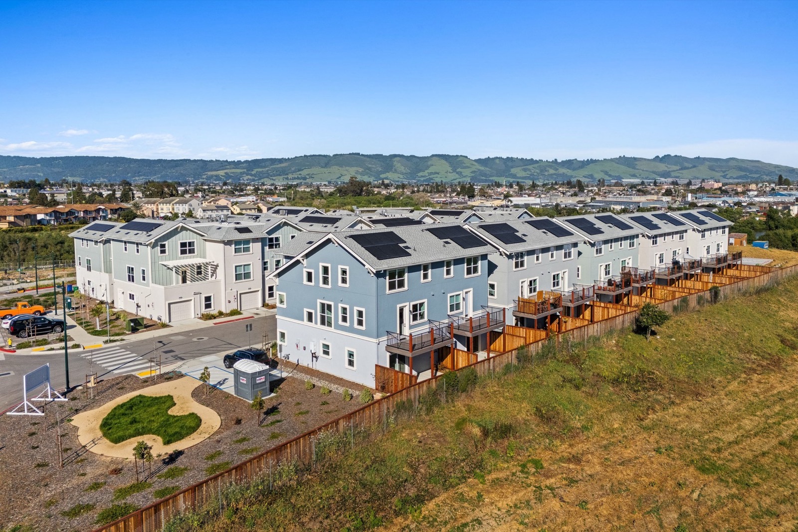 Completed Hillcrest homes with rooftop solar and the Pajaro Valley hills behind