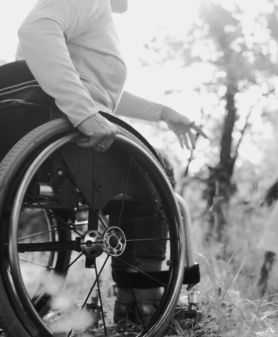 A wheelchair user outdoors among trees