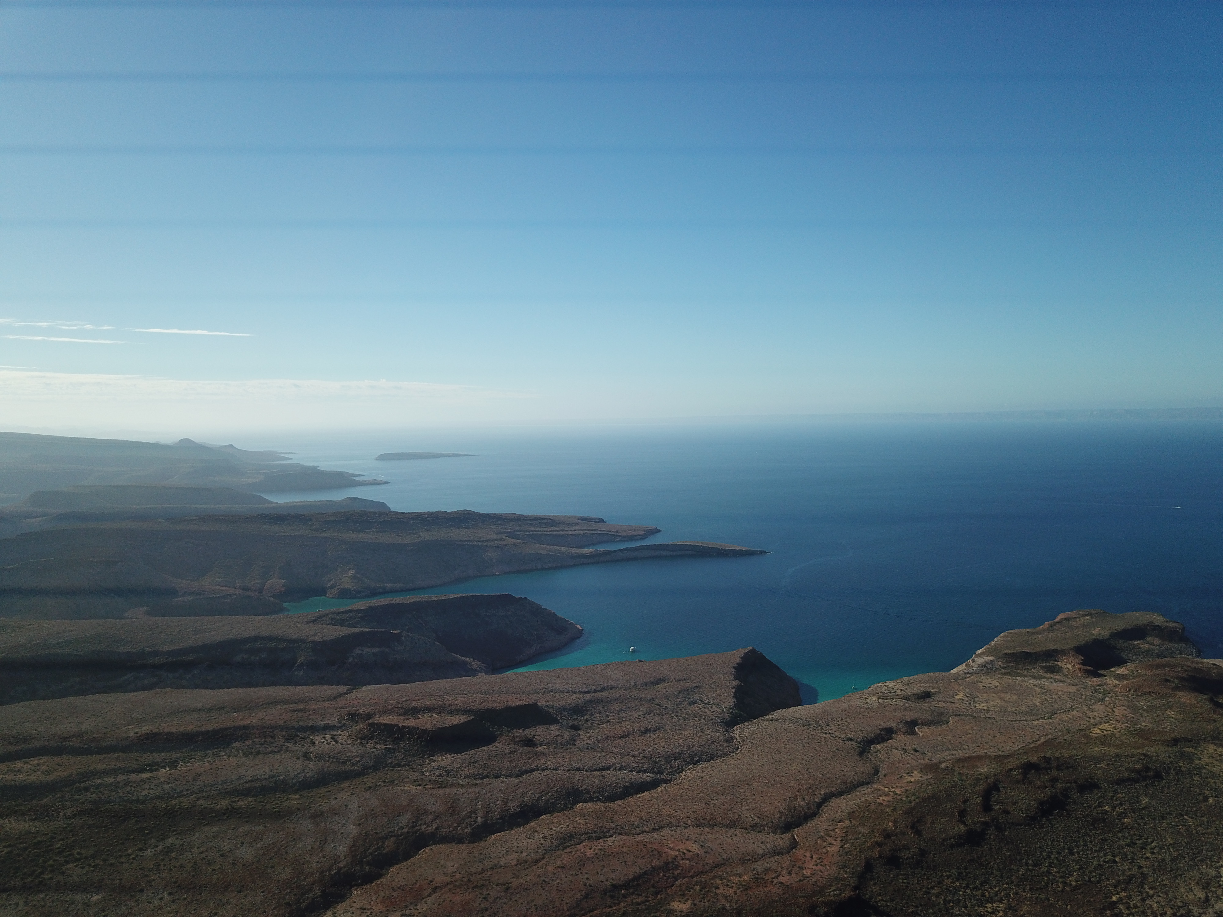 Baja coastline from altitude, turquoise bay meeting deep blue sea