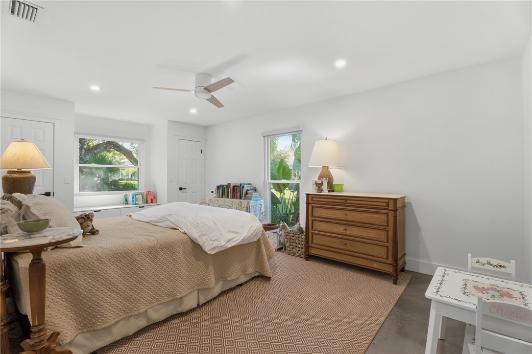 Room featuring neutral wall paint, recessed lighting, a modern ceiling fan, multiple windows, and smooth-finish concrete flooring