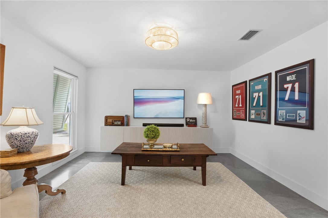 Living area featuring grey tile flooring, a neutral color palette, recessed lighting, and a built-in cabinetry unit