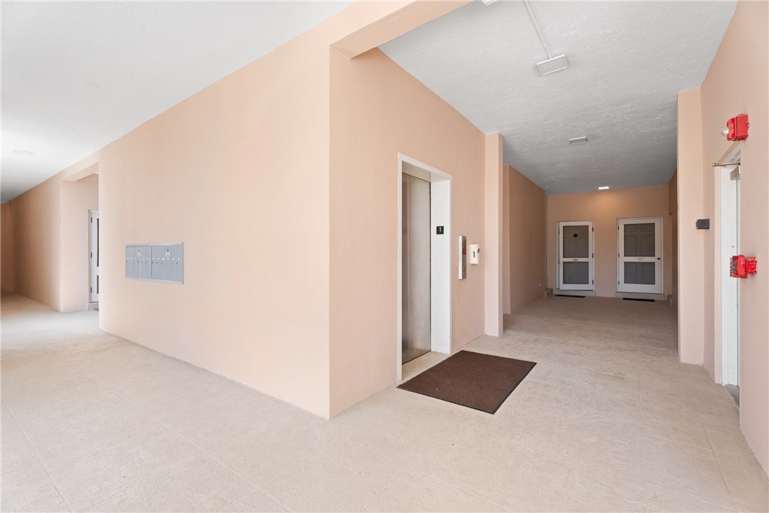 Building hallway featuring light-toned walls and tile flooring
