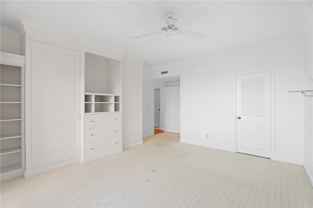 Room featuring extensive built-in cabinetry with crown molding, integrated shelving, and drawers