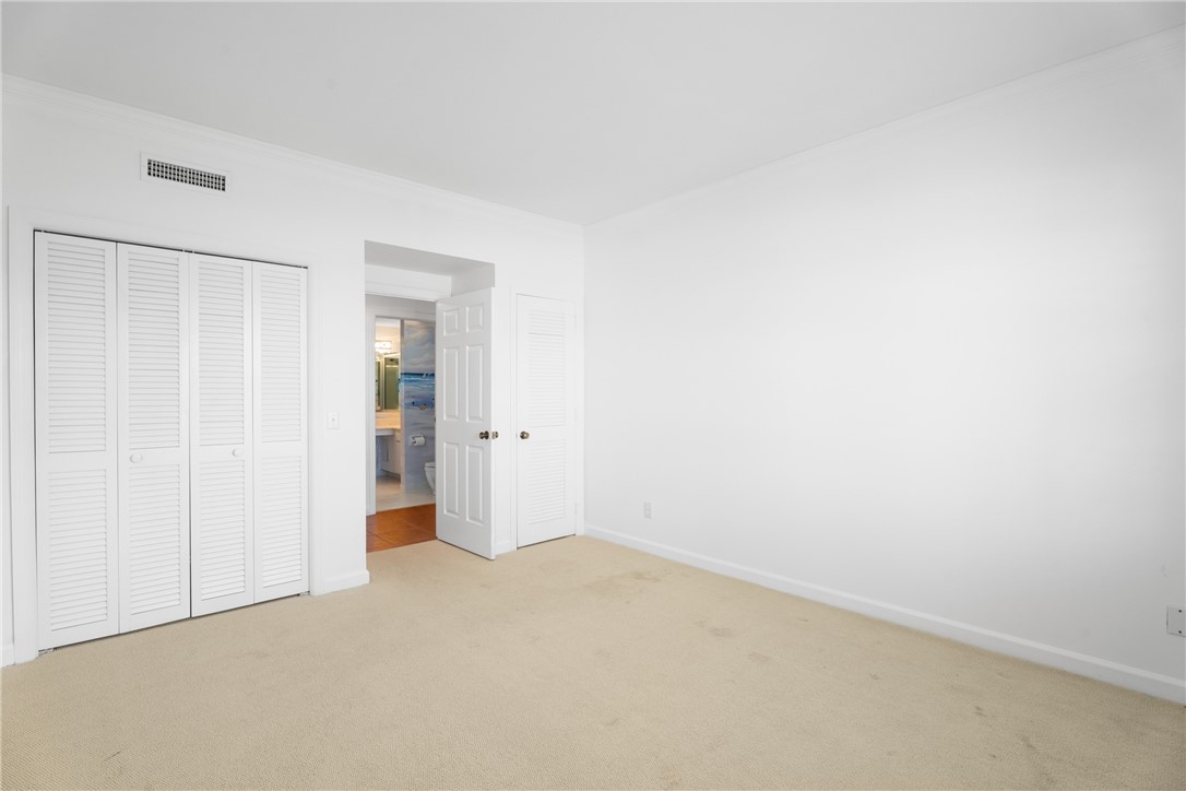 Room featuring neutral-toned carpeting, white walls, and white baseboards