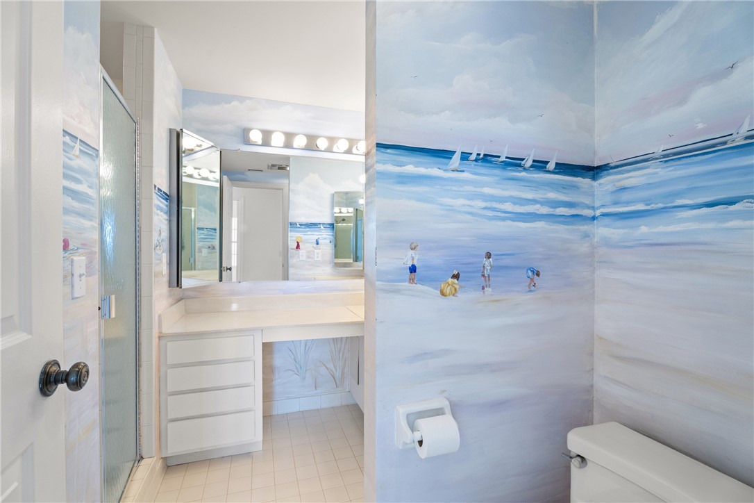 Bathroom featuring a glass-enclosed shower, a vanity with integrated countertop and storage drawers, and a wall-mounted medicine cabinet with mirror