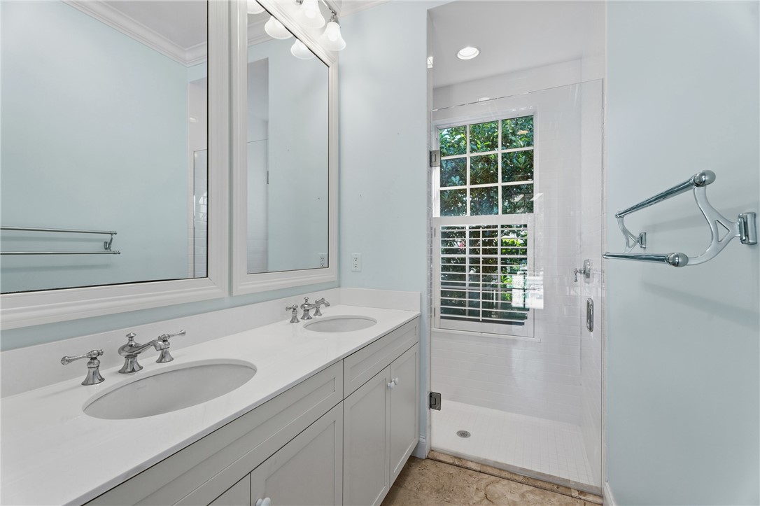 Dual vanity featuring white cabinetry, undermount sinks, and polished chrome fixtures