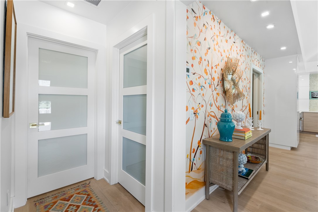 Entryway featuring a decorative accent wall, light wood-finish flooring, and recessed ceiling lighting