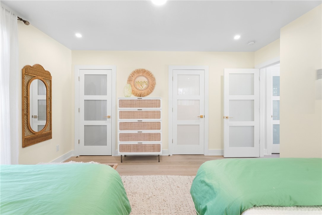 Recessed lighting illuminates the light-toned walls and wood-finish flooring