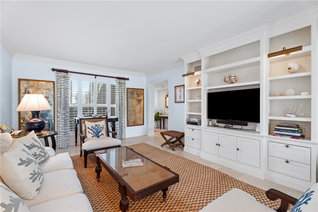 Living area featuring a built-in media center with integrated shelving and task lighting