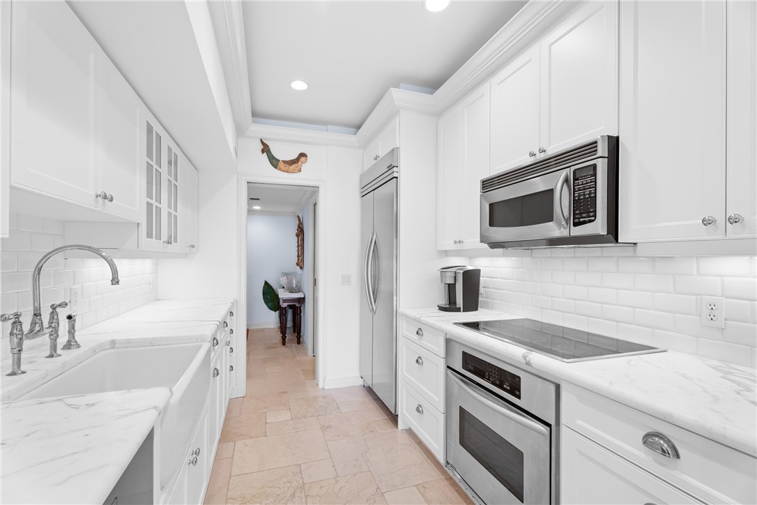 Bright kitchen featuring white shaker cabinetry and a subway tile backsplash
