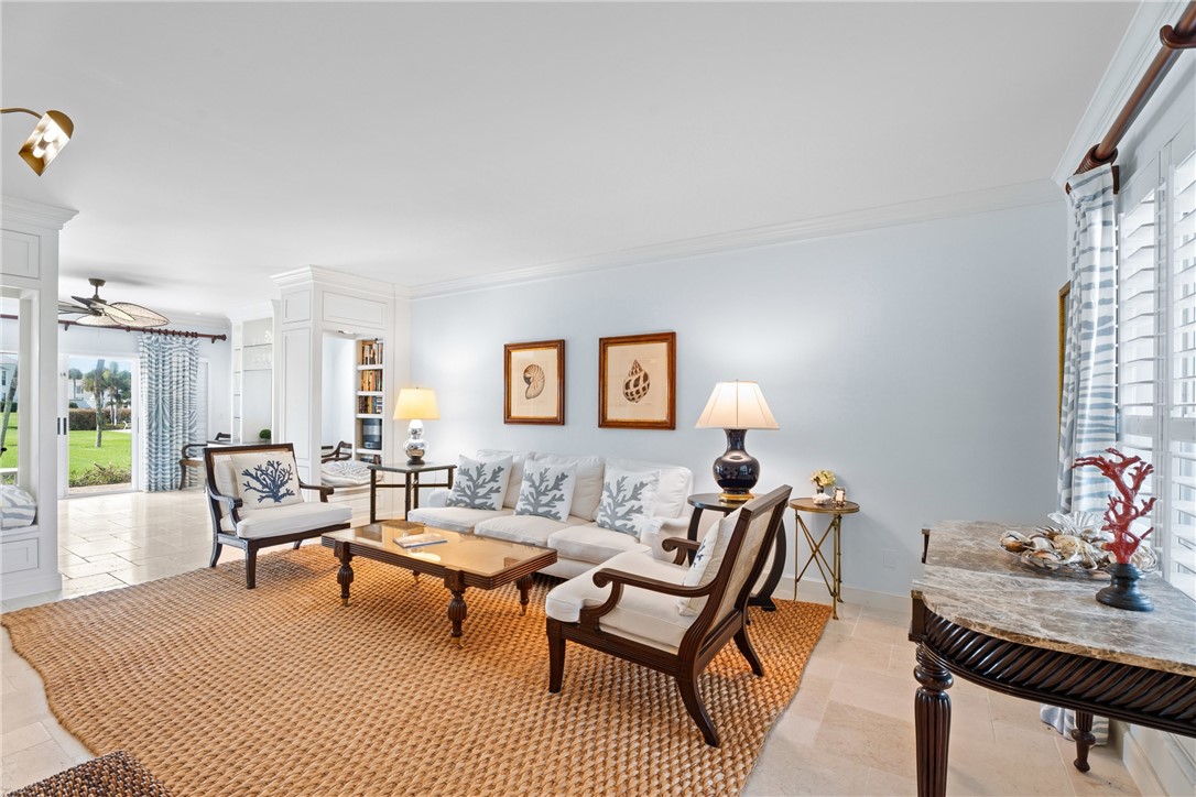 Living area featuring crown molding, a built-in window seat, and light tile flooring