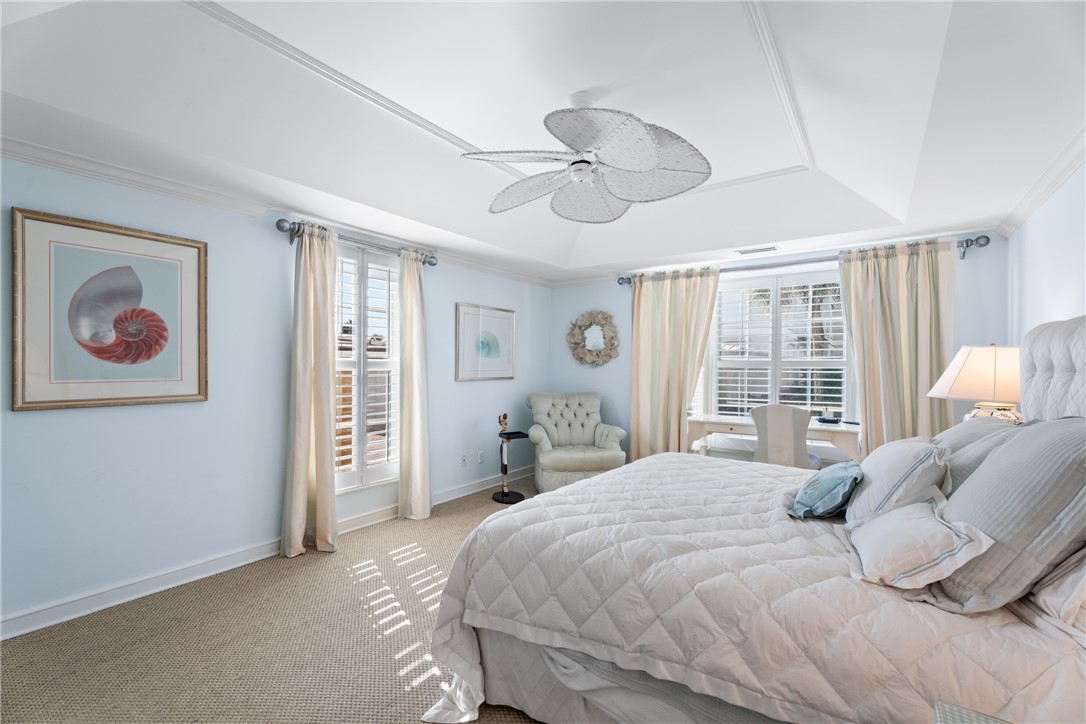 Spacious room featuring a tray ceiling, recessed lighting, and a decorative ceiling fan