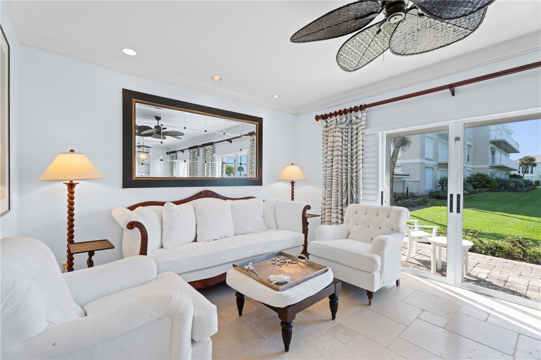 Bright living space featuring large format floor tiling and crown molding