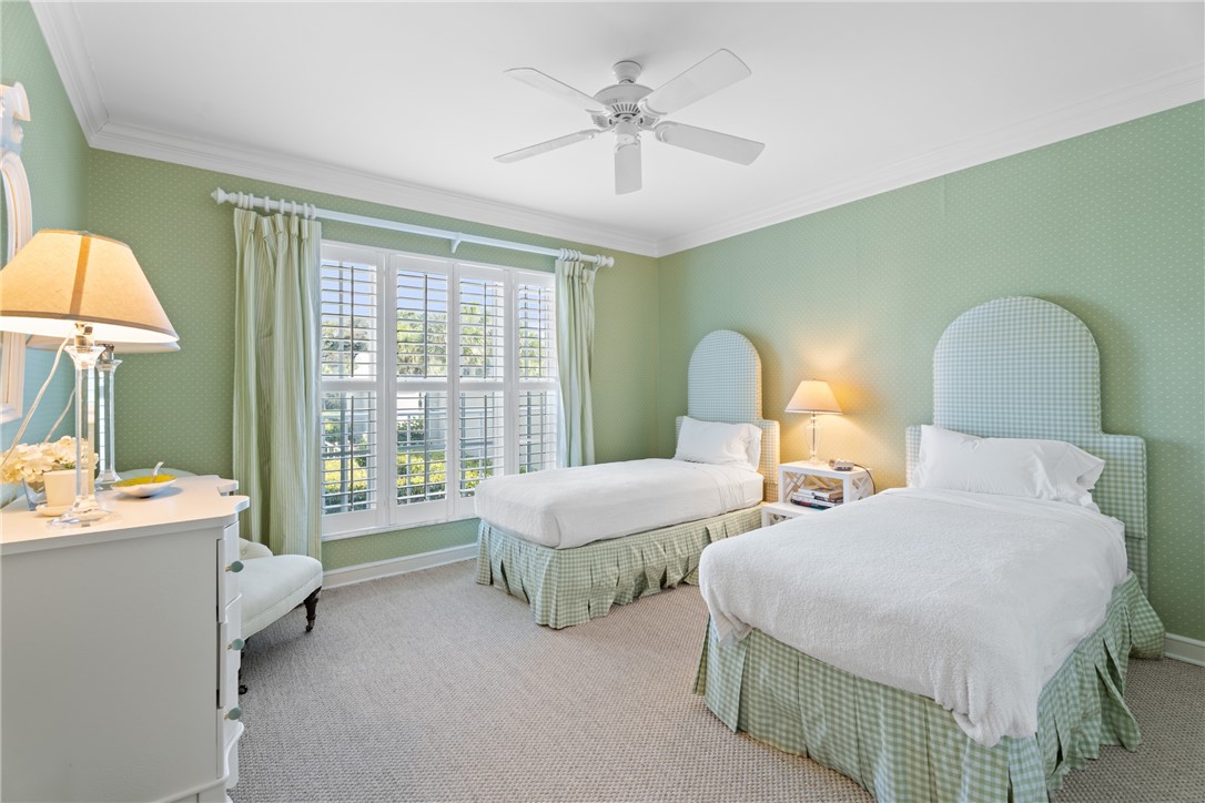 Room with patterned wallpaper, crown molding, and a ceiling fan
