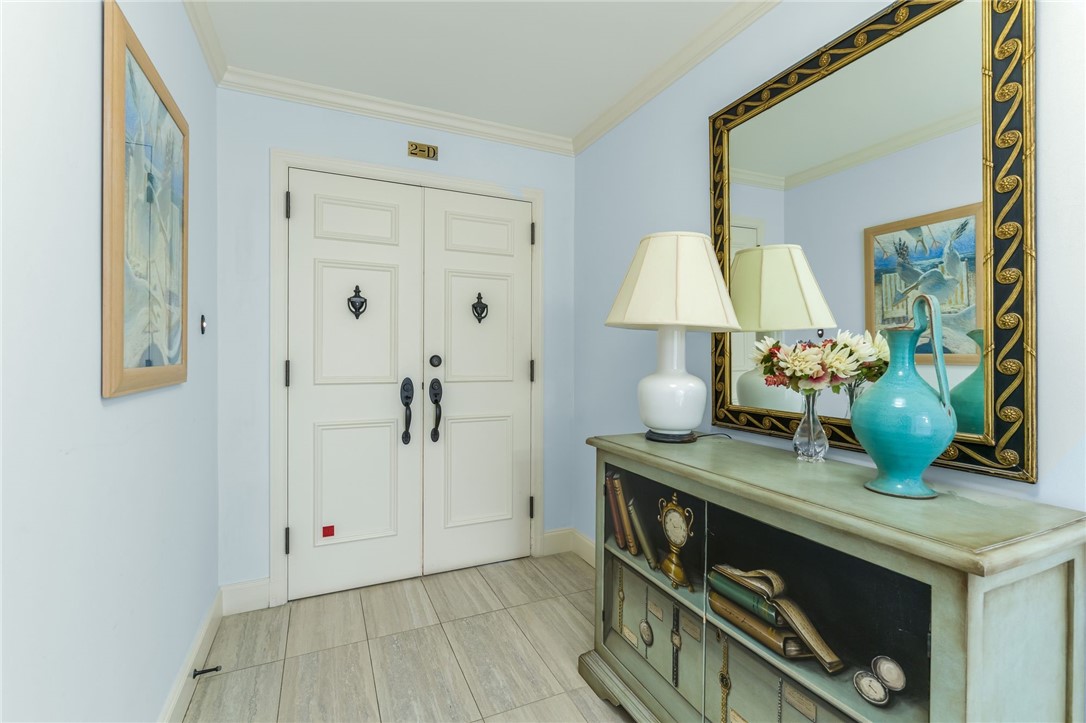 Double entry doors, crown molding, and tiled flooring