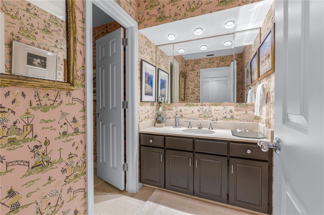 Vanity with a white countertop and integrated sink, framed by a mirrored wall