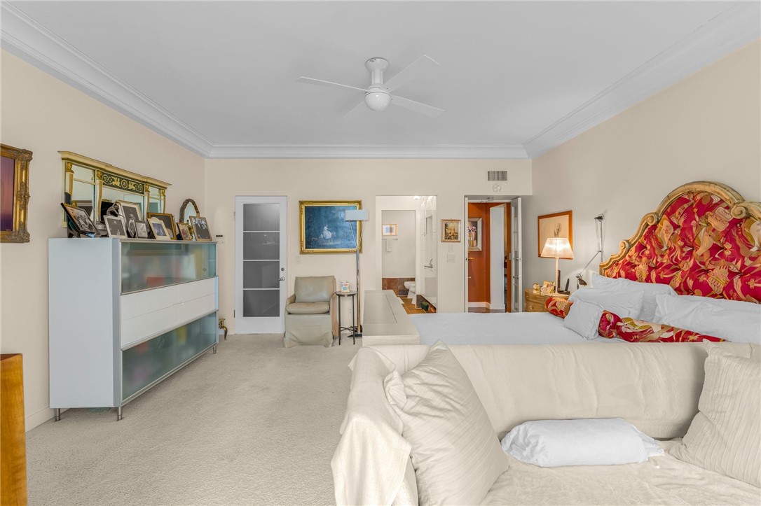 Recessed ceiling, crown molding, ceiling fan, and carpeted flooring