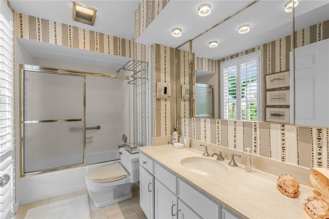 Spa-inspired bathroom featuring dual vanities with quartz countertops, polished nickel fixtures, and abundant storage