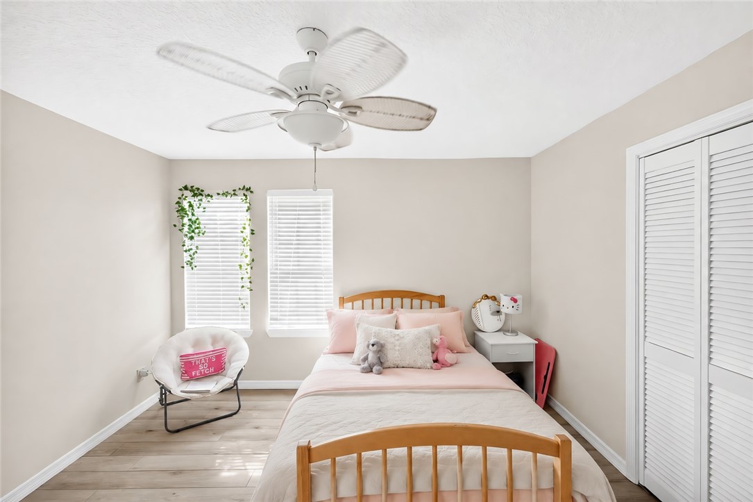 Recessed lighting, ceiling fan, wood-finish flooring, two windows with blinds, and bi-fold closet doors