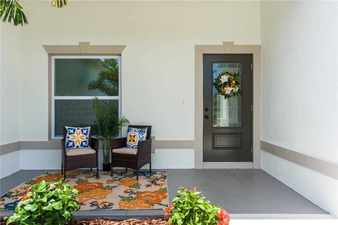 Covered entry with a dark-paneled door featuring decorative glass