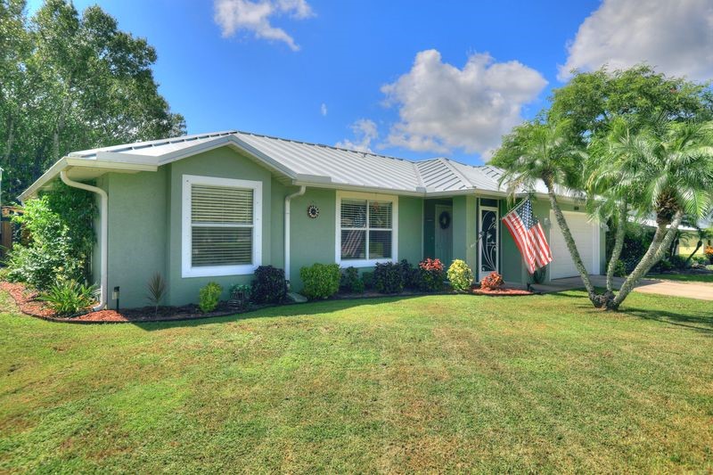 Stucco exterior with a metal roof and white trim