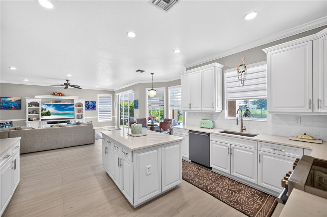 White cabinetry, light-toned countertops, and wood-finish flooring