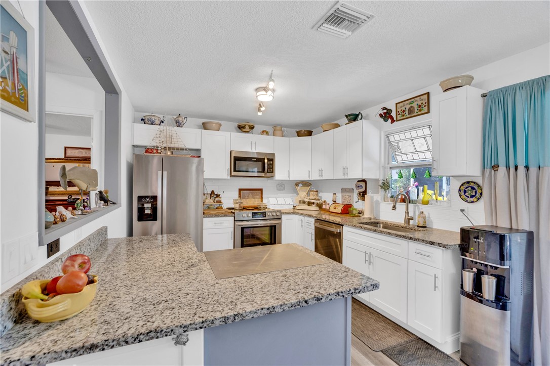 Updated kitchen with granite counters and white cabinetry