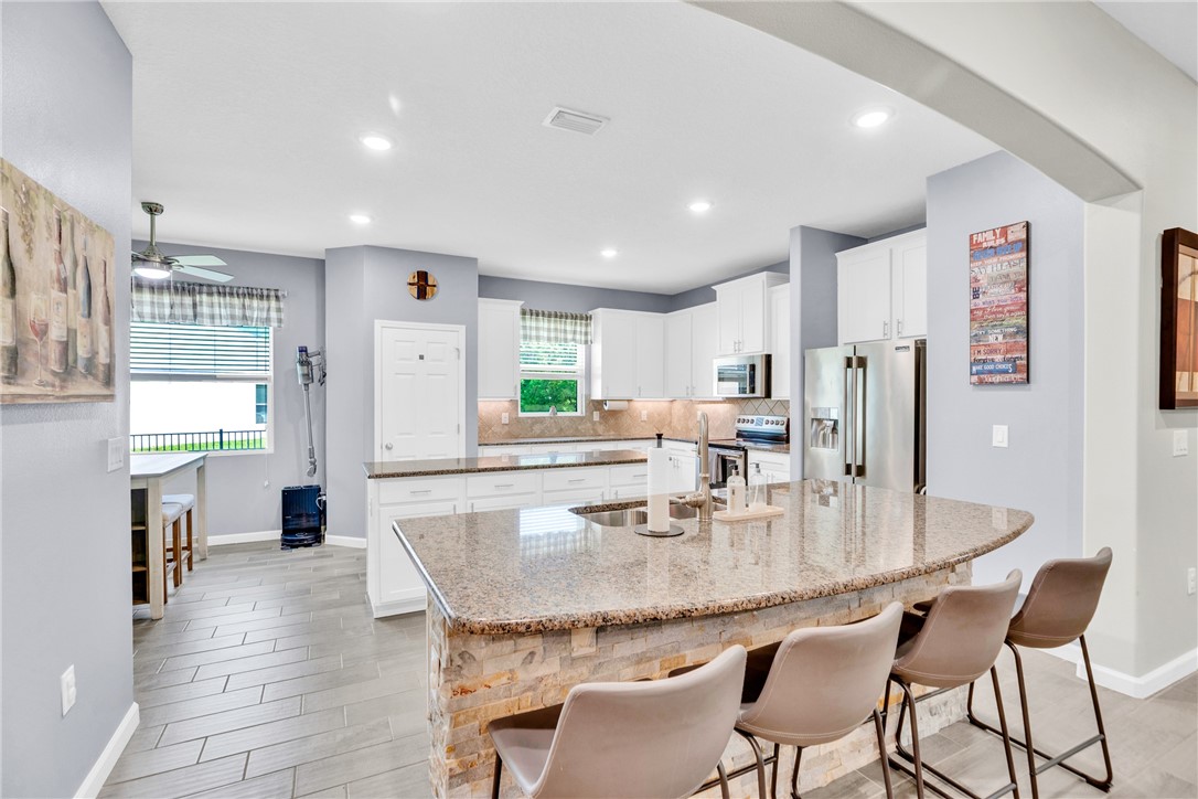Dual island kitchen with granite counter tops and stone face island