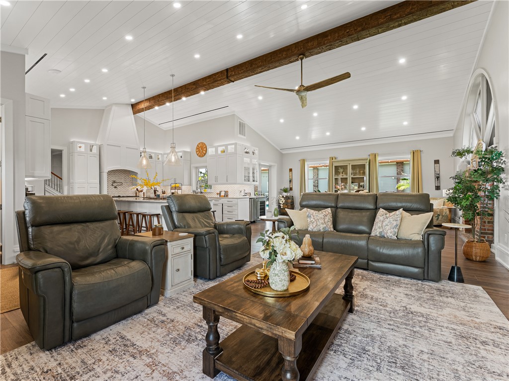 Vaulted shiplap ceiling with exposed wood beam, recessed lighting, and a ceiling fan