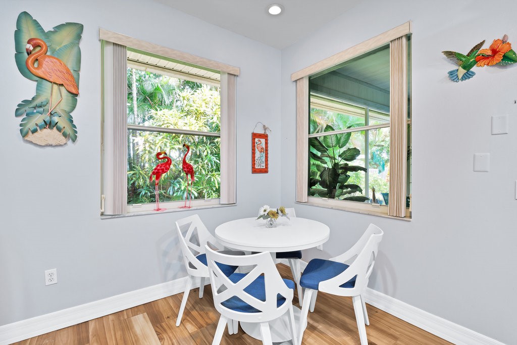 Windowed corner featuring two large windows, wood-finish flooring, and recessed ceiling lighting