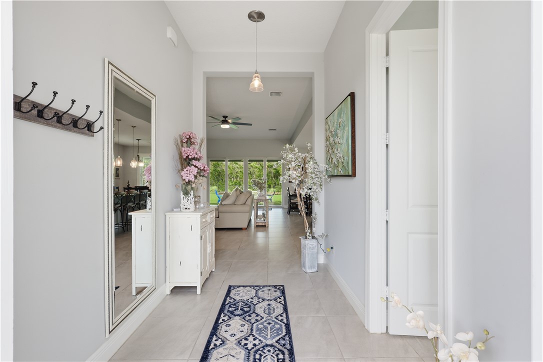 Foyer entryway featuring light-toned tile flooring, recessed lighting, and a pendant fixture
