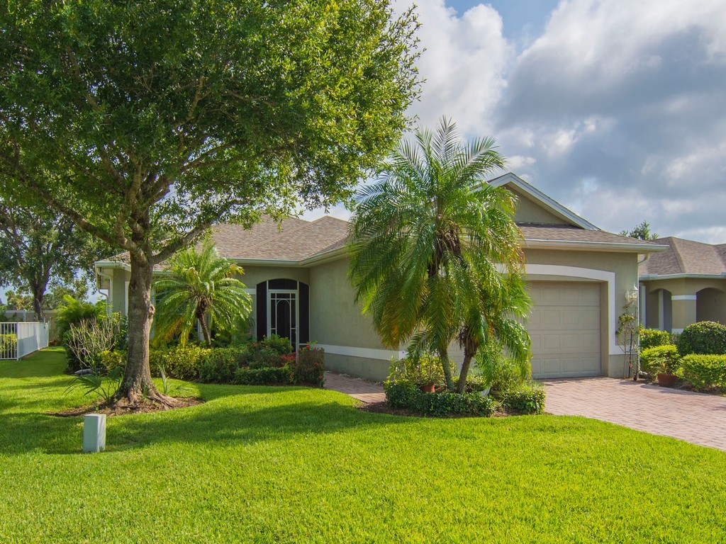 Single-story residence featuring a neutral-toned exterior, an integrated garage, and a paver driveway
