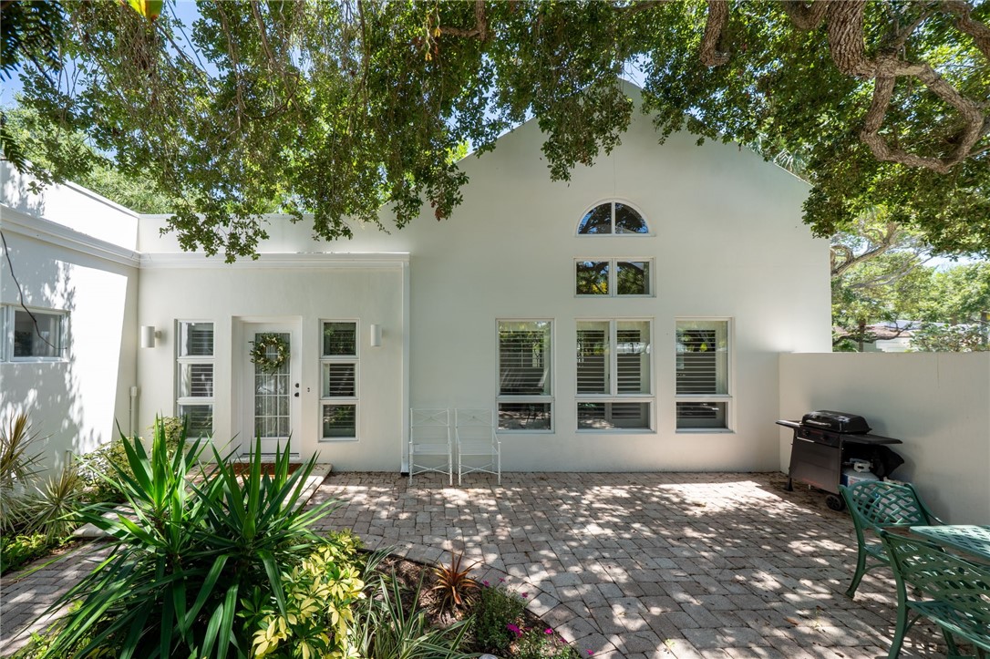 White stucco exterior featuring a gabled roofline and an arched window