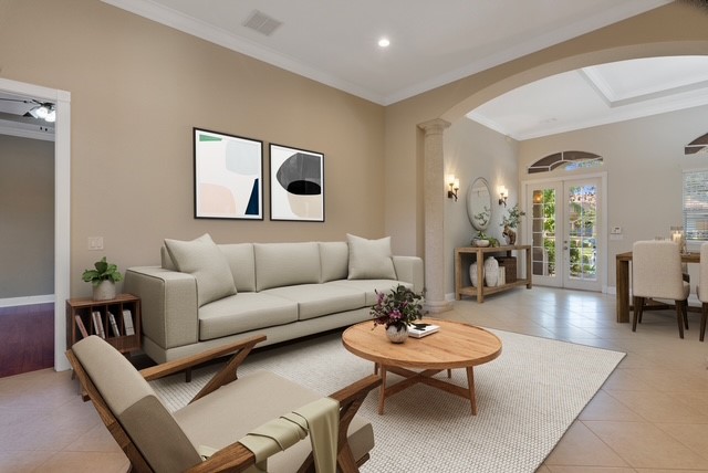 Virtual Staged living area featuring a cased opening with crown molding, recessed lighting, and a broad arched entryway